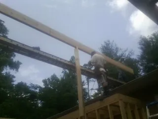 Carpenter setting a ridge beam over a new addition frame — Ice Dam Removal by Roofing Brothers in Fairbury