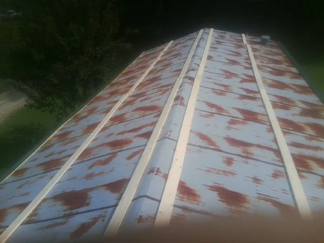 Rusted metal roof panels with new wood purlins before replacement — Storm Damage Roof Repair in Fairbury by Roofing Brothers
